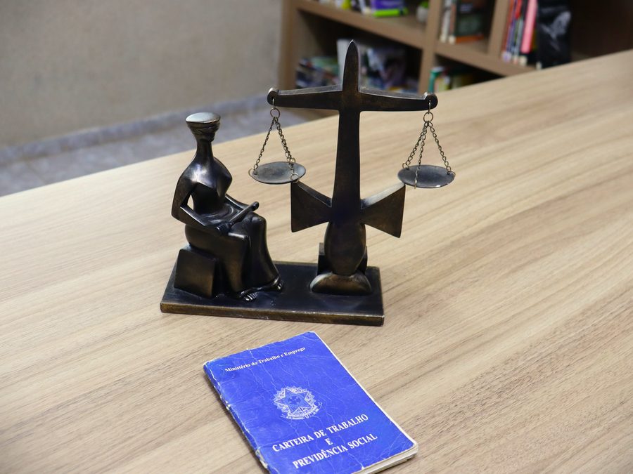 Escritório da Badry Advocacia — balança da justiça e Carteira de Trabalho